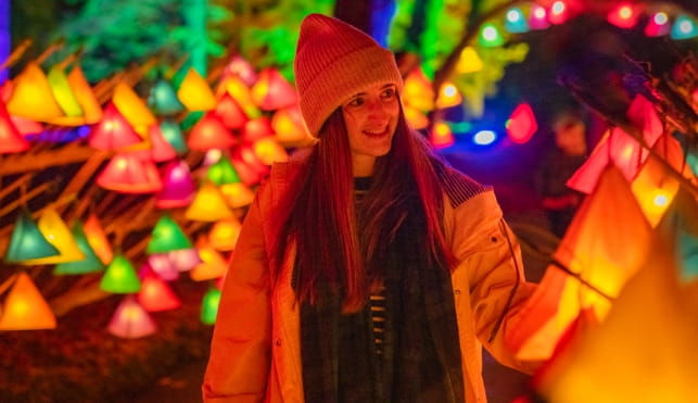 Woman walking by some lit lanterns